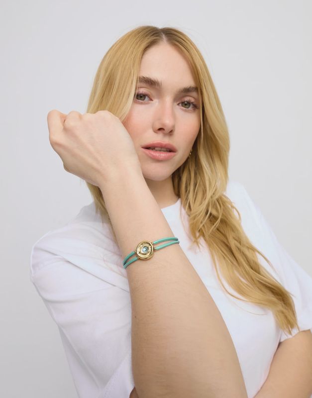 Uno de 50 Ser Intuitiva bracelet with double leather straps and gold eye charm worn in lifestyle setting