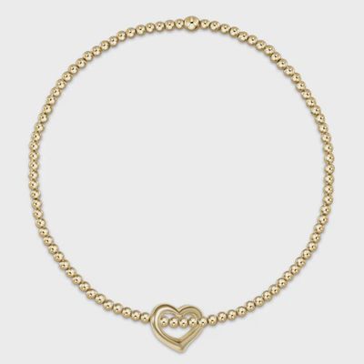 Gold beaded bracelet with small gold love charm pendant displayed on white background