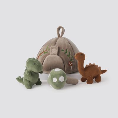 Set of three soft plush dinosaur toys in pastel colors with a velboa textured cave carrying case in studio lighting