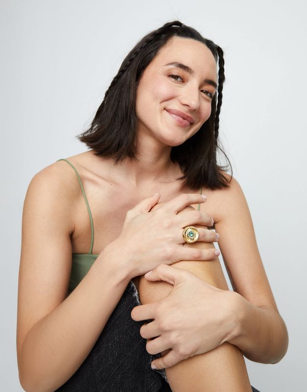 Gold Eye Signet Ring with faceted green crystal stone worn on hand in lifestyle setting