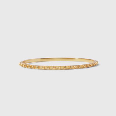 Gold and mixed metal studded stacking bangle from Julie Vos displayed on wrist in lifestyle setting