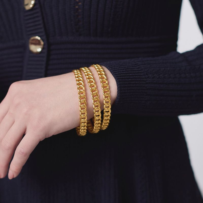 Julie Vos Dolce bangle bracelet in 24K gold plating worn on wrist in a lifestyle setting