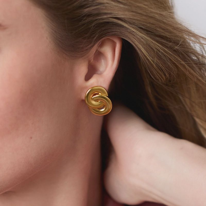 Julie Vos Infinity Post Earrings in 24K gold plate, 0.9 inches, worn in a lifestyle setting