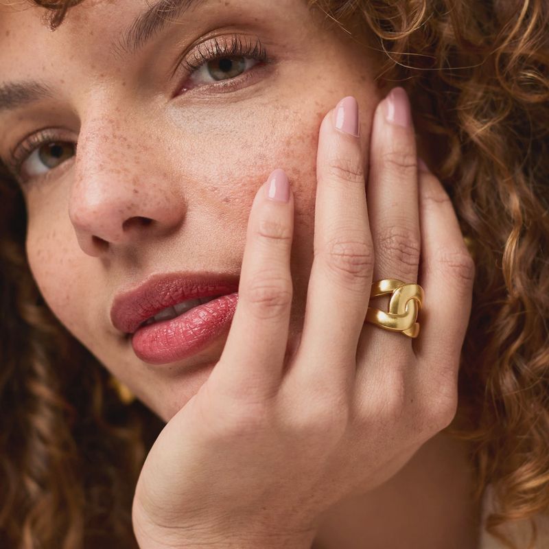 Julie Vos Infinity Ring in 24K gold plate worn on hand in natural light, showcasing the polished band and luxurious finish