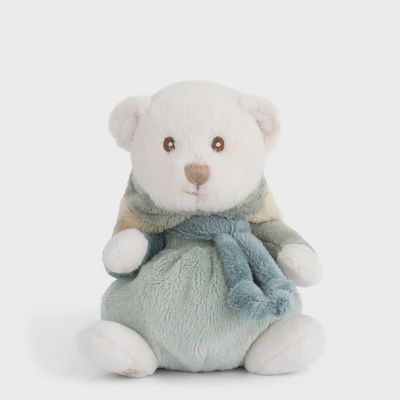 Small tan plush bear wearing a pink bunny hoodie, positioned in a cozy lifestyle setting