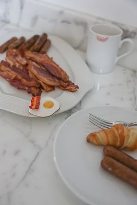 Nora Fleming Wakey Wakey mini brunch serveware displayed on a table with fresh pastries and coffee cups