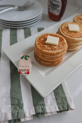 Nora Fleming Ho Ho Woah Vintage Sled mini in a festive holiday table setting with seasonal décor