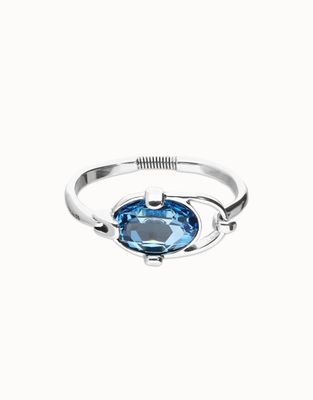 Uno de 50 Ser Deslumbrante bangle featuring blue faceted crystal with polished metal setting on neutral background