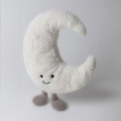 Jellycat Amuseable Moon plush toy with embroidered face on a soft surface, showing the cream-colored fabric and cute expression