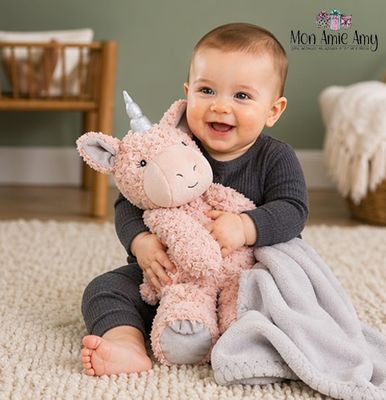 Baby playing with pink unicorn plush lovey and soft blanket on carpet in warm nursery setting