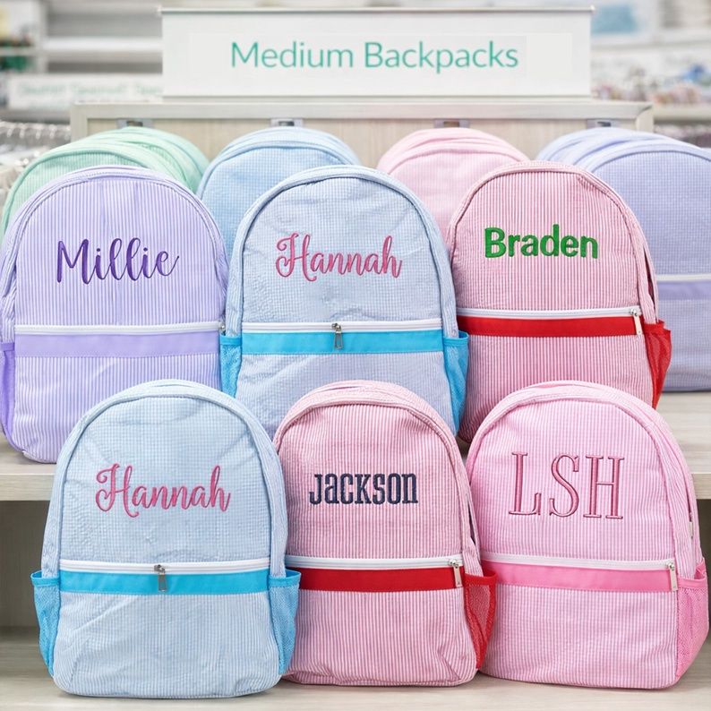 Mint seersucker medium backpacks with side pockets displayed in a retail store, featuring personalized kids school bags in pa