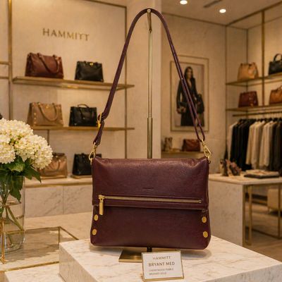 Hammitt VIP Med cherrywood pebble leather crossbody with brushed gold hardware displayed in luxury retail store