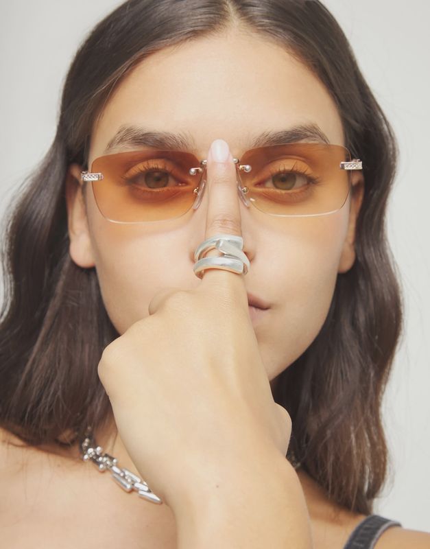 Uno de 50 three intertwined shapes ring worn on hand, showcasing layered geometric design and metallic finish