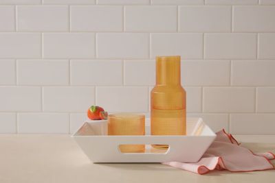 Nora Fleming square melamine serving tray in a 12x12 size displayed on a table setting with food and tableware