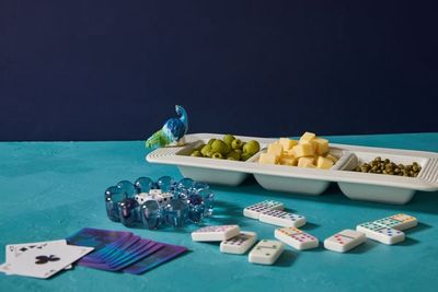 Hand-painted peacock mini tabletop piece by Nora Fleming displayed on a table setting with decorative styling