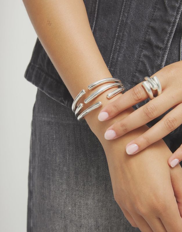Uno de 50 Roots bangle bracelet with intertwined organic shapes worn on wrist in lifestyle setting