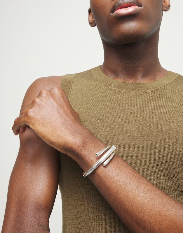 Uno de 50 Roots bangle bracelet with three intertwined organic shapes worn on wrist in lifestyle setting