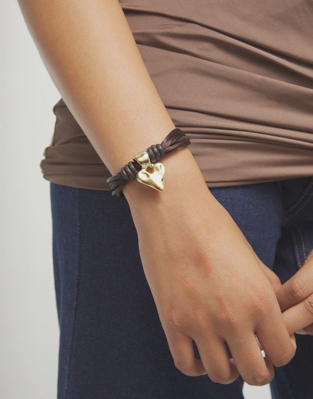 Handmade heart silk and leather bracelet from Uno de 50 Beat Collection worn on wrist in lifestyle setting