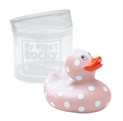 Baby pink rubber duckie with white polka dots floating in bathwater during a lifestyle bath time scene