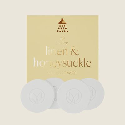 Musee Linen and Honeysuckle shower steamers displayed on a white background, featuring two pale yellow aromatherapy bath bombs