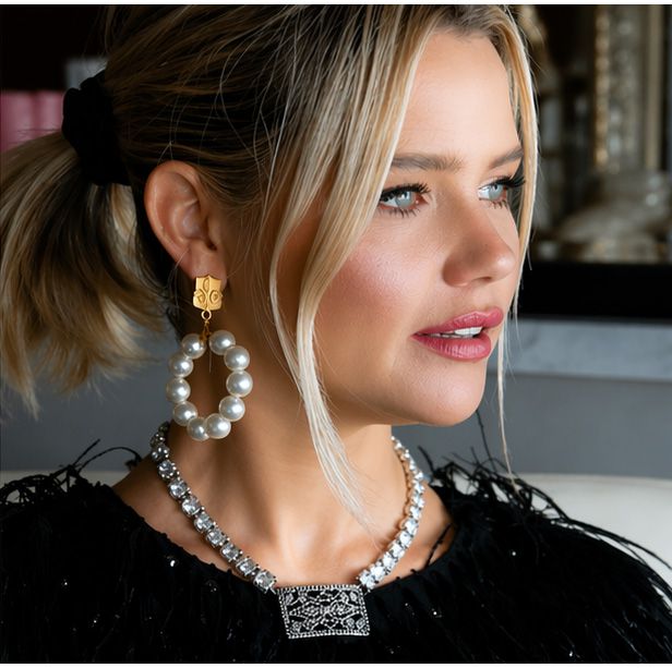 Close-up of woman wearing French Kande Bastienne Swarovski crystal necklace with Boucle pendant and pearl earrings