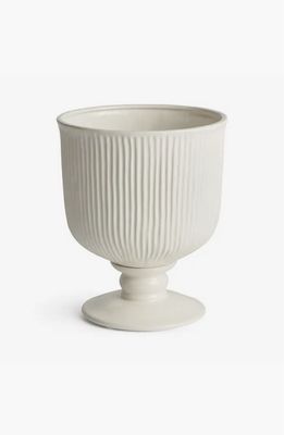 White ribbed ceramic footed urn planter, 11 inches tall, with a tapered pedestal base on a neutral background