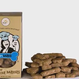 Peanut Butter Barker Treats from arcBARKS Dog Treat Company displayed in a lifestyle setting with a dog enjoying the treats.