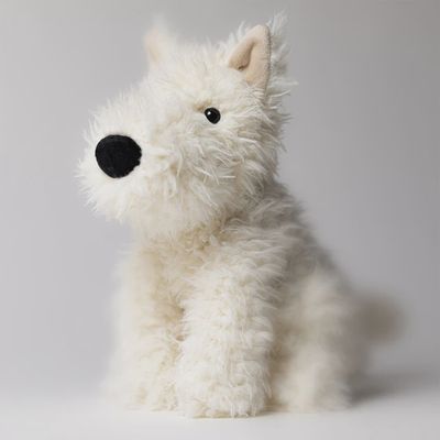 Jellycat Munro Scottie dog plush toy displayed with coordinating accessories in a styled lifestyle scene