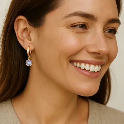 Gold huggie hoop earrings with small June charm detail in a lifestyle setting