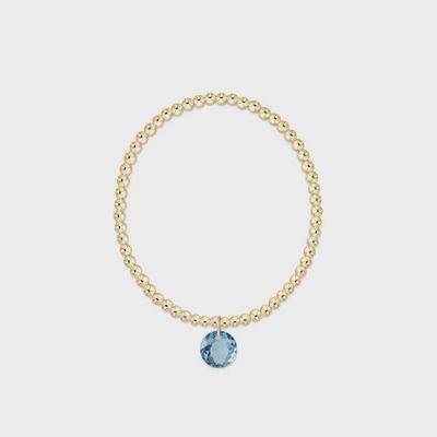 Gold 3mm beaded bracelet with March Reflection charm on white background