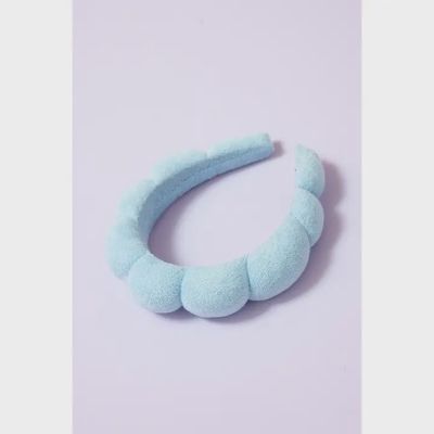 White terry cloth spa headband with elastic band, displayed on neutral background for beauty and face washing use