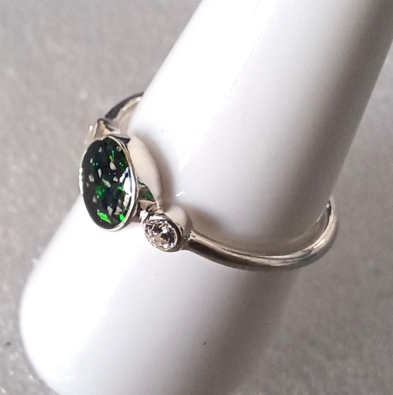 Round centre with two CZ stones set in rub over setting either side