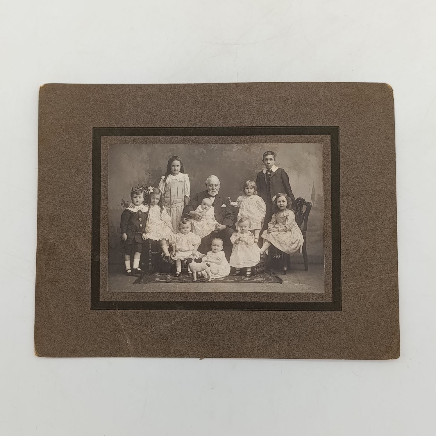 Antique photo of a Grandfather with 11 grandchildren - note the toy doggie 100mmx145mm (Probably from Burnley area, England)
