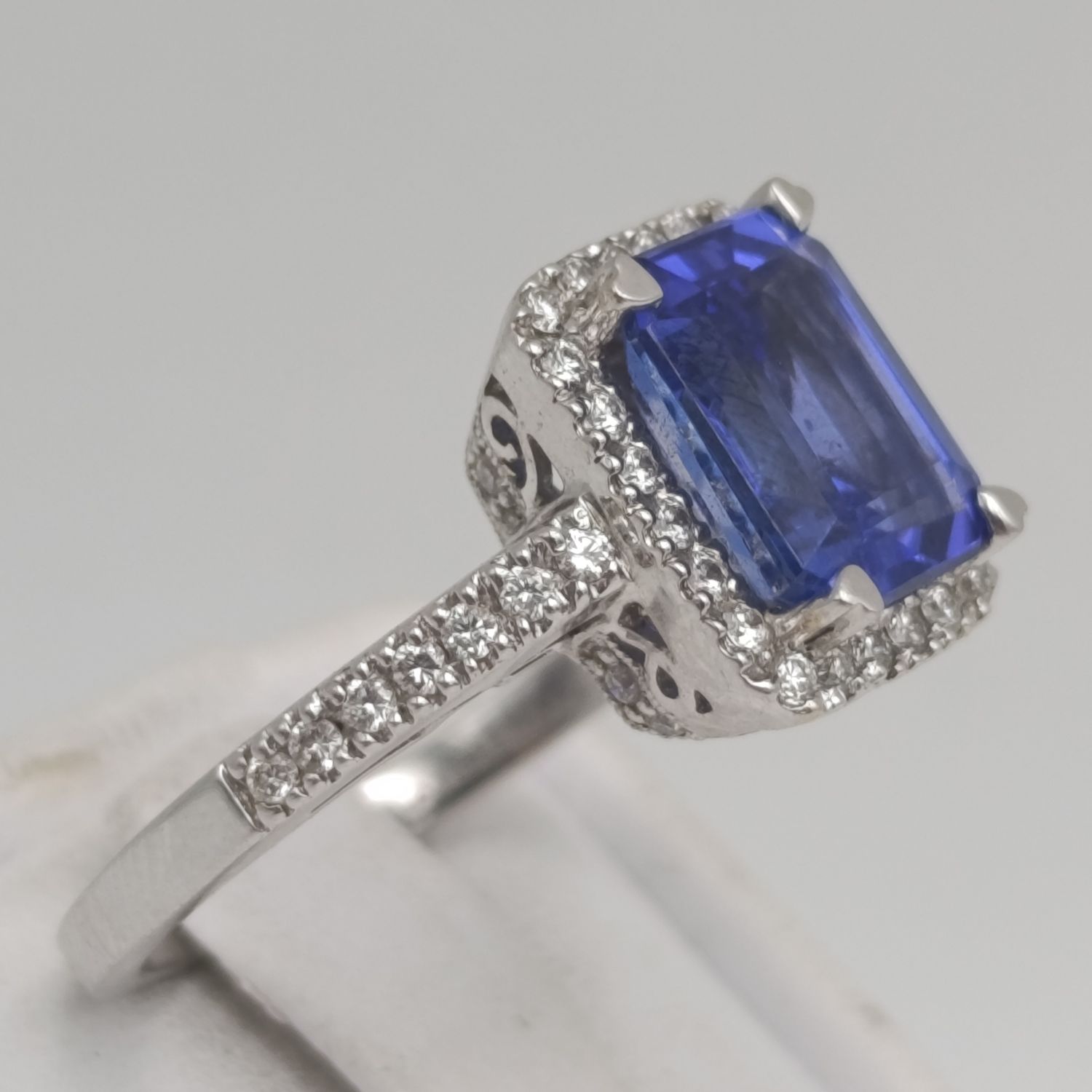 18kt White ring with blue stone surrounded by small diamonds - weighs 6.2 grams - size N 1/2