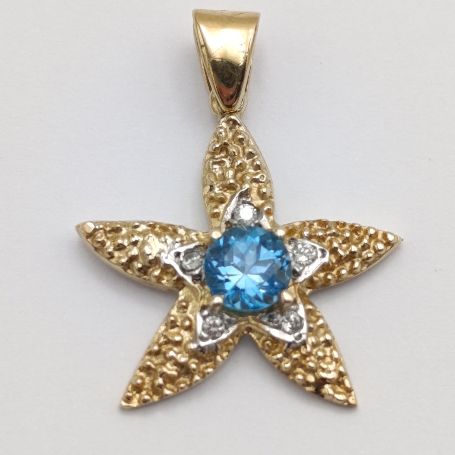 14kt Yellow gold starfish pendant with light blue topaz and small diamonds - weighs 3,2g
