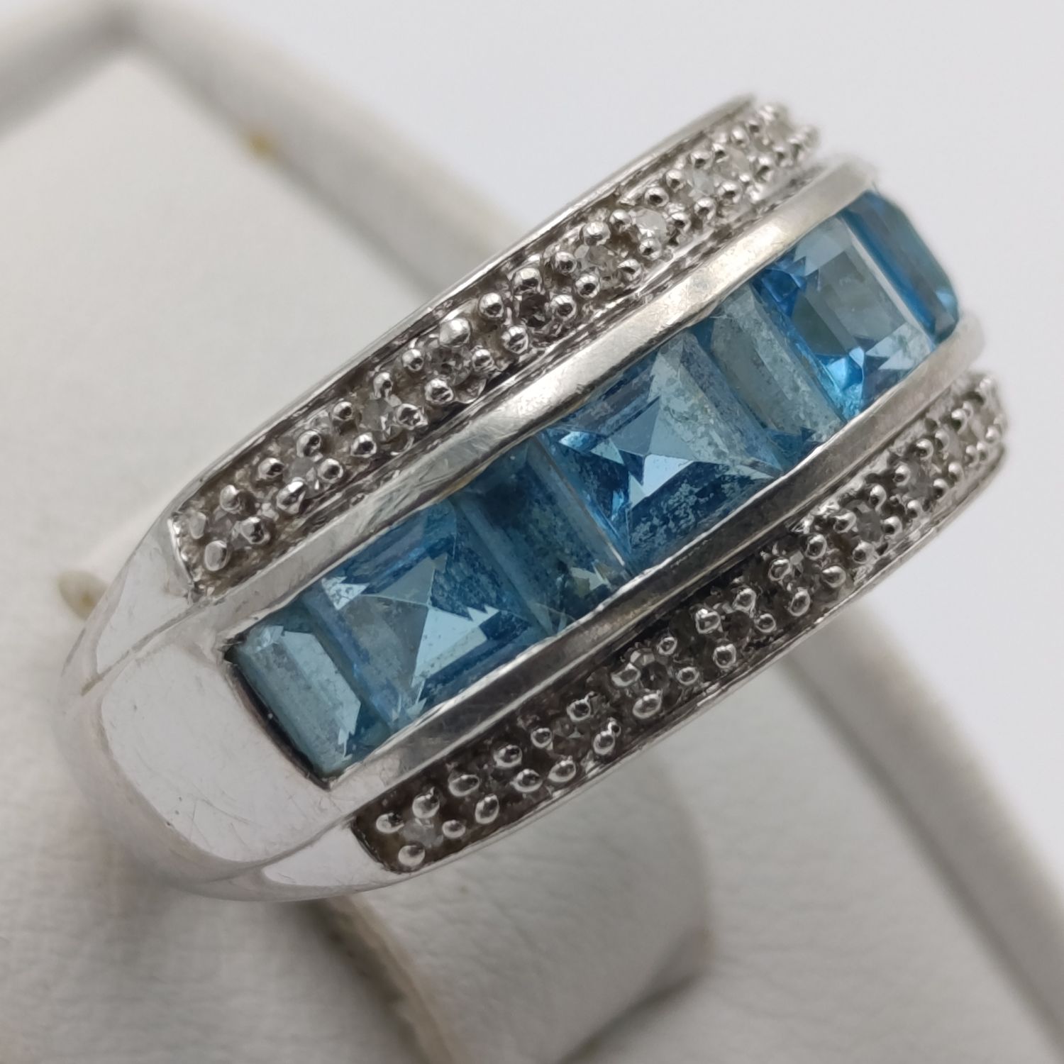 9kt white gold ring with 24 diamonds and 9 blue stones (aquamarine or topaz) weight 4.9g