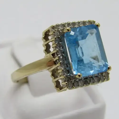 9kt Gold ring with 3.5ct blue topaz and small diamonds of 0.28ct in total - weighs 4.8g - size O/7