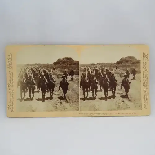Boer War stereoscope card #25 - Her Majesty`s Heroes marching into Colesberg after the Boers retreat