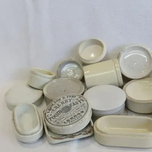 Lot of antique toothpaste and other holders and lids - 19 Pieces in total