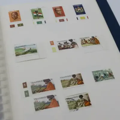 Album with over 1100 stamps including Transkei and Venda mint collections and a lot of USA stamps