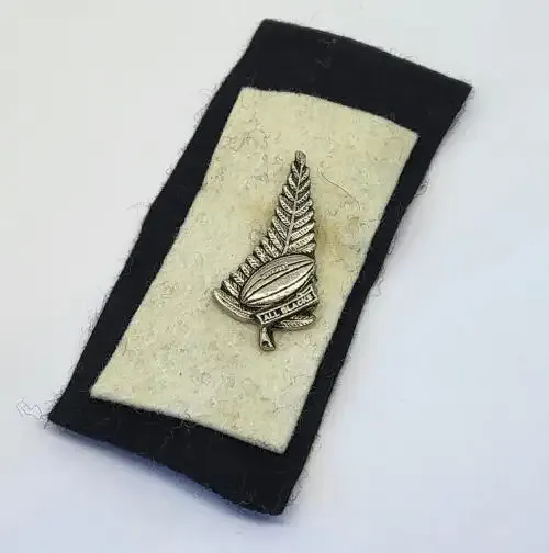Vintage All Blacks New Zealand rugby pin badge on felt background