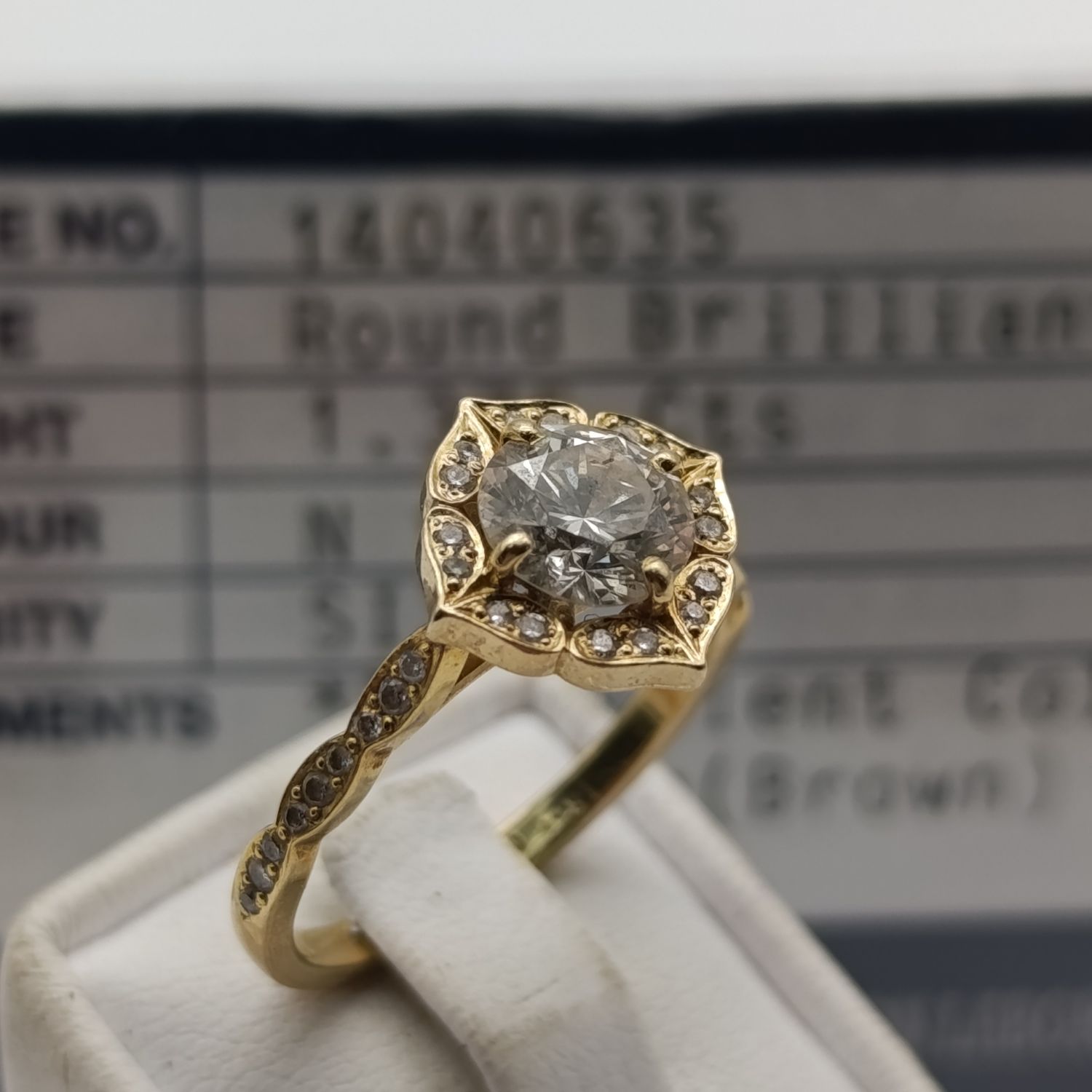 18kt Yellow gold diamond ring with 1.375ct graded diamond surrounded by 34 small diamonds - colour N, clarity SI3 - weighs 4.6g - size Q 1/2