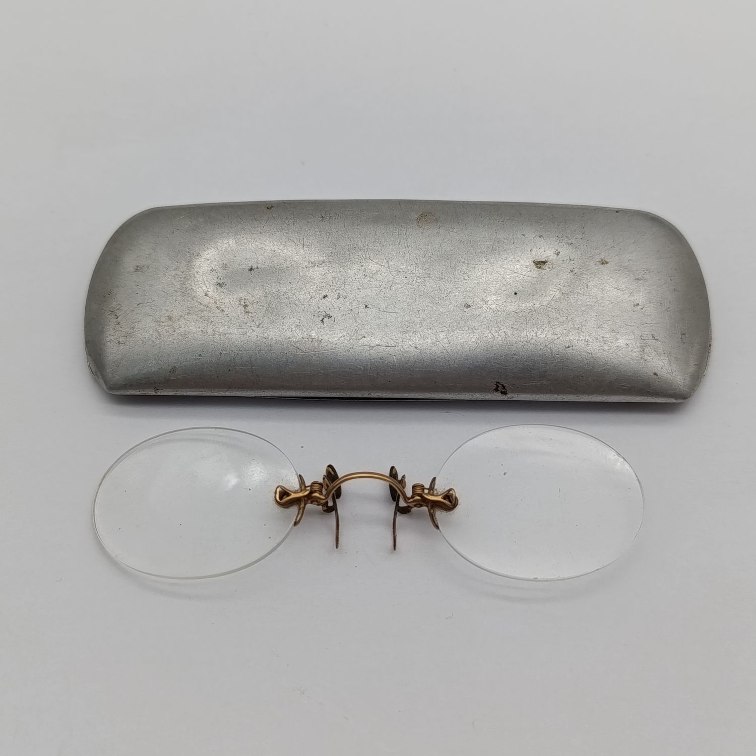 Pair of vintage prescription clip-on spectacles in aluminium tin box
