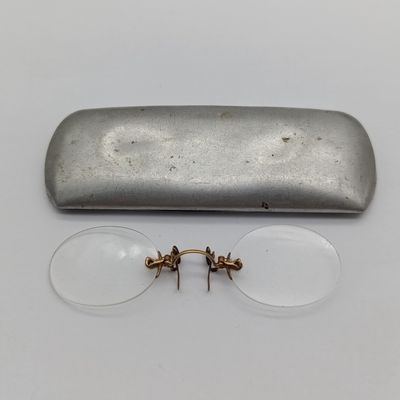 Pair of vintage prescription clip-on spectacles in aluminium tin box