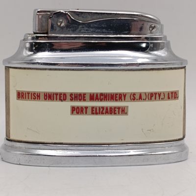 Vintage table lighter with British United shoe Machinery advertising - working