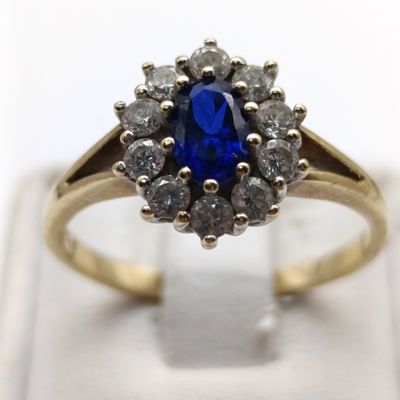 9kt yellow gold ring with dark blue topaz and clear stone accents