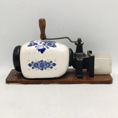Vintage porcelain coffee grinder on wooden plaque