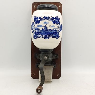 Vintage porcelain coffee grinder on wooden plaque