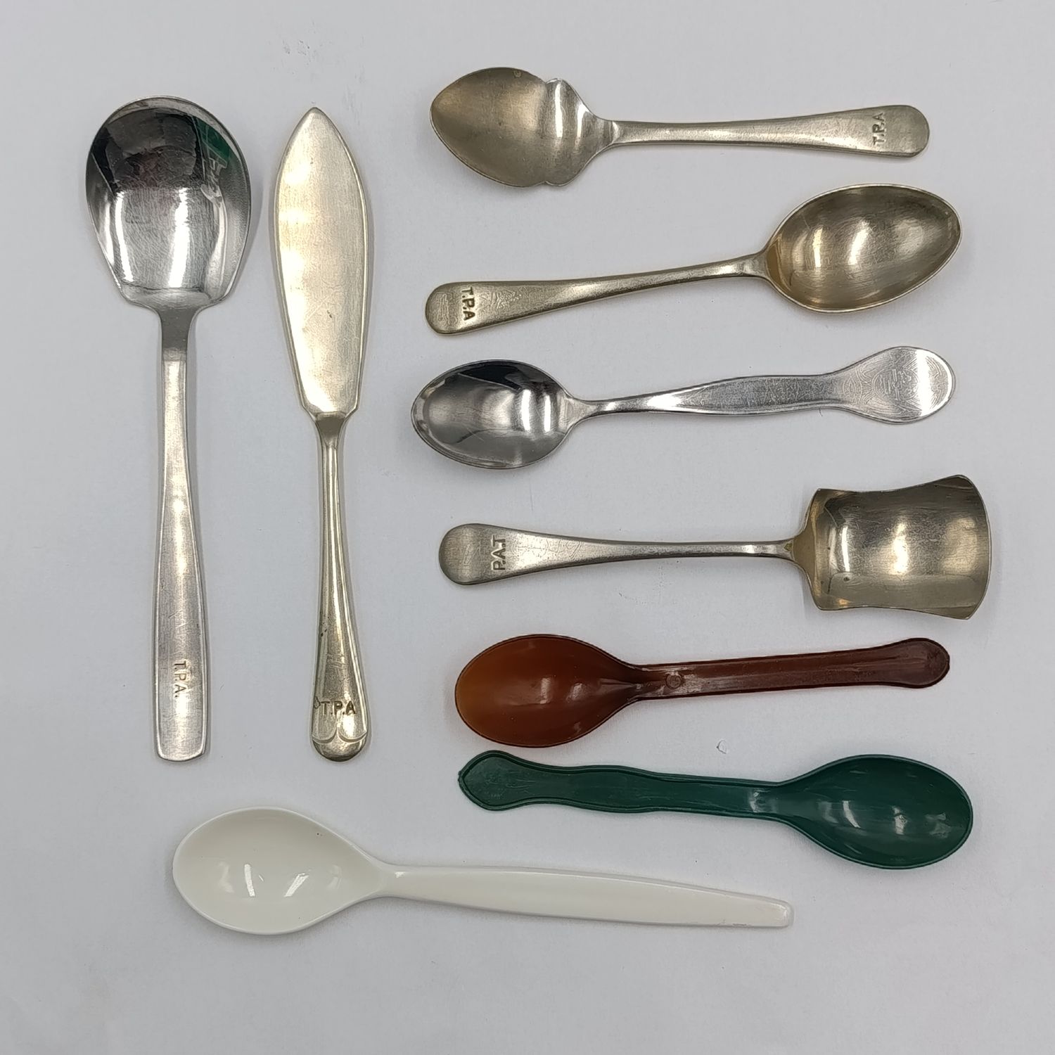 Set of spoons depicting the history of Transvaal Provincial Administration hospitals Catering Department - 6 metal and 3 plastic types - one sugar spoon with wrong spelling of TPA (P.A.T)