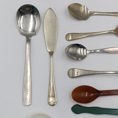 Set of spoons depicting the history of Transvaal Provincial Administration hospitals Catering Department - 6 metal and 3 plastic types - one sugar spoon with wrong spelling of TPA (P.A.T)